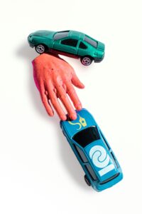 two car toys and one hand