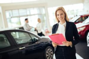 A lady wearing black coat standing with a car 